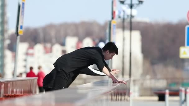 Två unga män utför parkour tricks med kullerbytta i slutet — Stockvideo