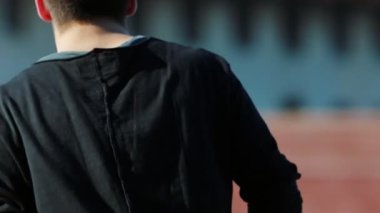 Genç akrobatik adam öne koşar ve taklalar atar.