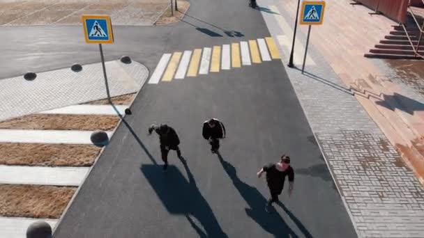 Vista aérea das ruas urbanas. Três homens caminhando na estrada — Vídeo de Stock