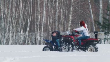 Bir kış ormanı. Bir adam kar motosikleti ve kadın etrafında sürme ile sorunu giderme
