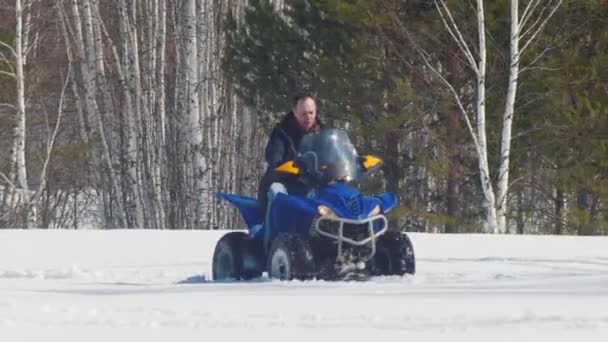 Un bosque de invierno. Un hombre montando una gran moto de nieve — Vídeos de Stock