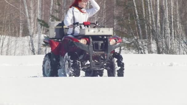 Uma floresta de inverno. Uma mulher inspirada com cabelo de gengibre montando grande snowmobile — Vídeo de Stock