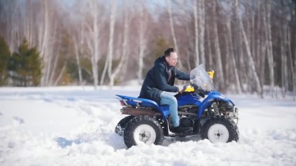 Зимовий ліс під час денного світла. Холодна погода. Чоловік їде на великому снігоході — стокове відео