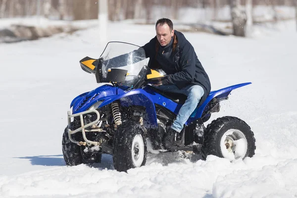 Un hombre adulto con chaqueta montando moto de nieve en el bosque de invierno — Foto de Stock