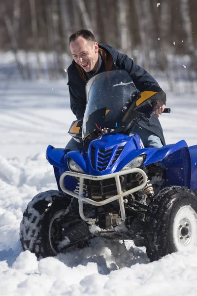 Un bosque de invierno. Clima frío. Un hombre adulto montando una gran moto de nieve — Foto de Stock