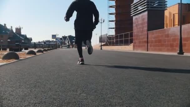 Городские улицы. Спортсмен бежит по улице — стоковое видео
