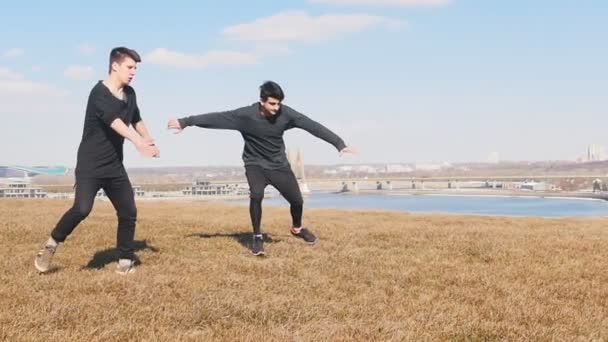 Twee acrobatische mannen trainen hun tricking vaardigheden buiten — Stockvideo
