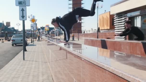 Három fiatal sportos férfi akadályok leküzdésében a városi utcákon — Stock videók