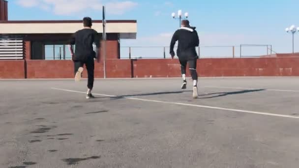 Двоє молодих людей долають перешкоди на міських вулицях — стокове відео