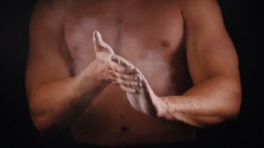 Atletik bir adam bir talk ile ellerini çırparak