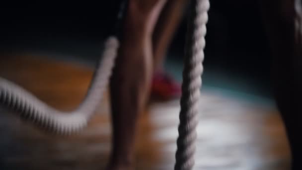 Кросфіт. Навчання в спортзалі. Чоловік тренує руки з мотузками, які б'ються на підлозі — стокове відео