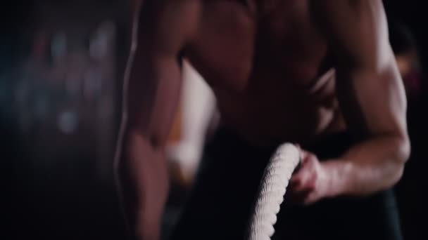 Crossfit. Un uomo che si allena le mani con le corde che colpiscono sul pavimento — Video Stock