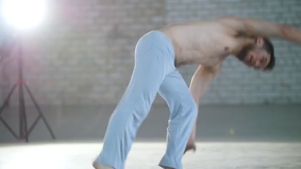 Een man traint zijn vaardigheden. Capoeira-elementen worden weergegeven. Flips ter plaatse maken — Stockvideo