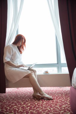Pencere de oturan zencefilli bir kadın.