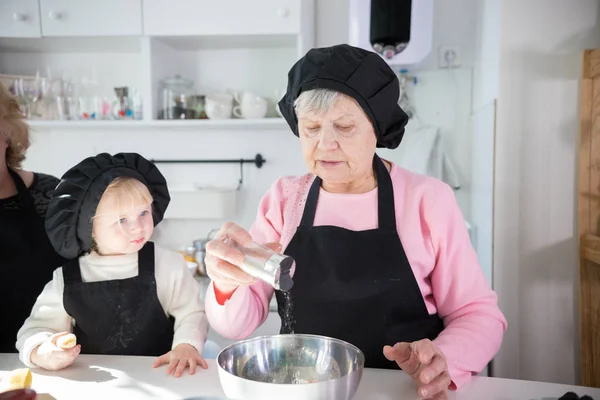 Οικογένεια που φτιάχνει τηγανίτες. Μια γριά γυναίκα που σαλτάρεί — Φωτογραφία Αρχείου
