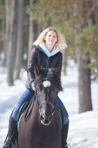 冬季森林一位年轻女子在雪地上骑着一匹黑马 — 图库照片