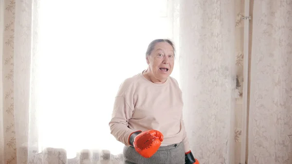 Старая улыбающаяся женщина в боксёрских перчатках — стоковое фото