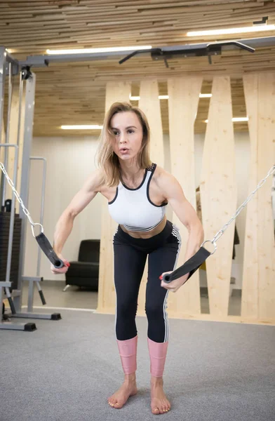 Mujer atlética joven haciendo ejercicios de fuerza en las manos en el gimnasio —  Fotos de Stock