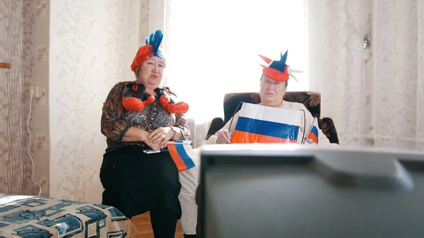 Две пожилые женщины смотрят телевизор в русских аксессуарах — стоковое фото