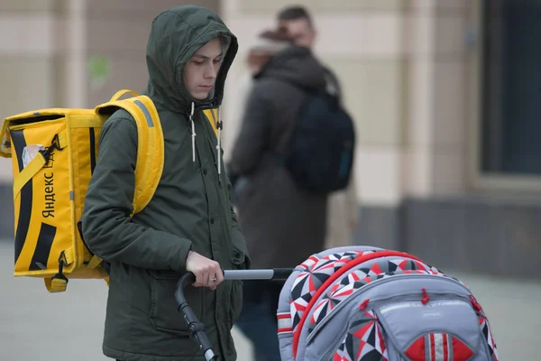 Rusland, Kazan 10-04-2019: stedelijke straten. Een Food delivery man staand met een kinderwagen — Stockfoto