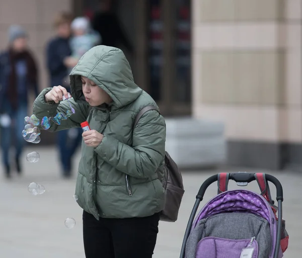 Rusland, Kazan 10-04-2019: stedelijke straten. Een kleine jongen spelen met zeepbellen — Stockfoto