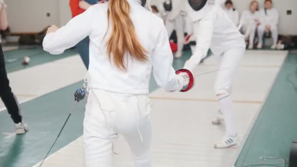 27 MARCH 2019. KAZAN, RUSSIA: Teenage girls fencers in white protective clothes fighting on a fencing tournament — Stock Video