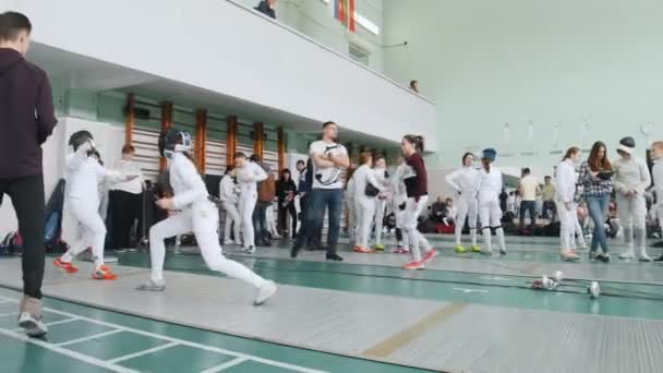 27 Mart 2019. Kazan, Rusya: Koruyucu kıyafetli gençler okul salonunda bir eskrim turnuvasında kavga ediyor — Stok video