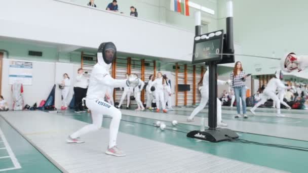 27 Mart 2019. Kazan, Rusya: Koruyucu kıyafetli gençler okul salonunda bir eskrim turnuvasında kavga ediyorlar. Bir kız bir puan alır — Stok video