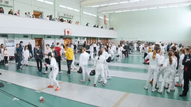 27 de março de 2019. KAZAN, RÚSSIA: Um grande torneio no salão com muitas pessoas. Adolescentes esgrimistas em roupas protetoras lutando — Vídeo de Stock