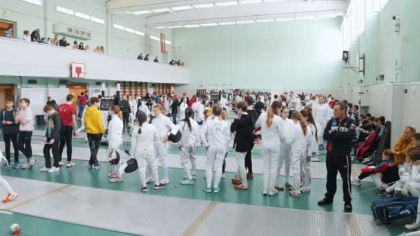 27 Mart 2019. Kazan, Rusya: Salonda çok sayıda insanla büyük bir turnuva. Gençler koruyucu beyaz giysiler mücadele eskrimciler — Stok video