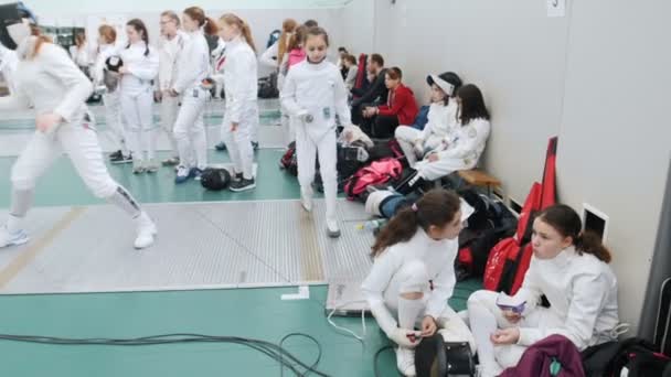 27 MARS 2019. KAZAN, RUSSIE : Un tournoi pour ados dans le hall. Les adolescents escrimeurs en vêtements de protection attendent leur tour — Video