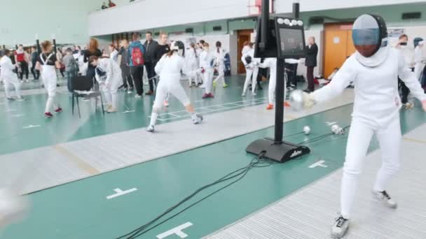 27 Mart 2019. Kazan, Rusya: Salonda çok sayıda insanla büyük bir turnuva. Beyaz koruyucu giysiler mücadele Gençler eskrimciler — Stok video