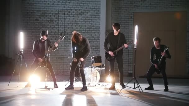 Een rockgroep met een herhaling. Mensen in zwarte kleren spelen hun onderdelen. — Stockvideo