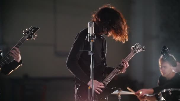 A rock group having a repetition. A soloist shaking his head with his long hair — Stock Video