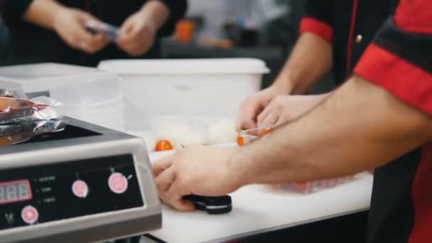 Restaurant keuken. Een chef-kok zet de cherry tomaten uit de container — Stockvideo