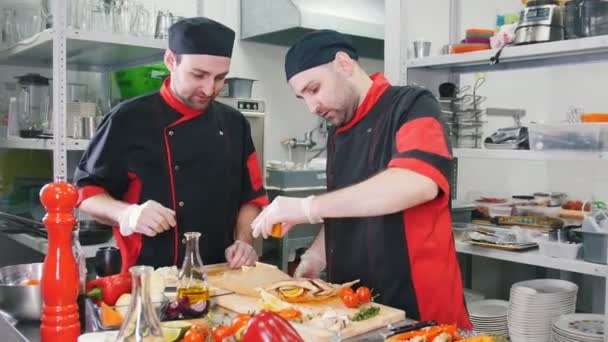 Dos hombres chefs trabajando en servir plato de pescado en la tabla de cortar — Vídeo de stock