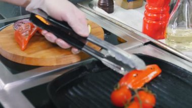 Restoran mutfağı. Ahşap plaka üzerinde ısıtmalı tavadan kızarmış sebze koyarak
