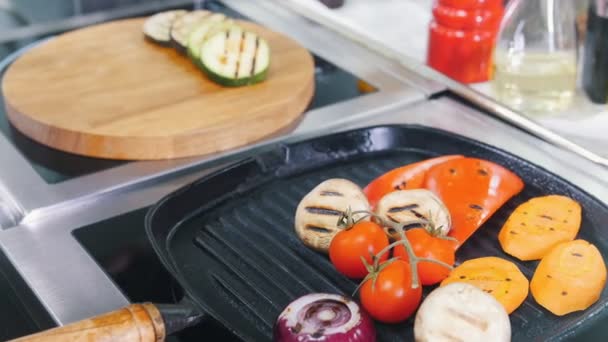 Ресторан кухня. Положить жареные овощи с сковороды на деревянную тарелку — стоковое видео