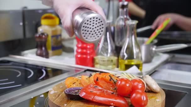 Serwowania smażonych warzyw na biurku. Umieszczenie roztopionej soli morskiej na szczycie — Wideo stockowe