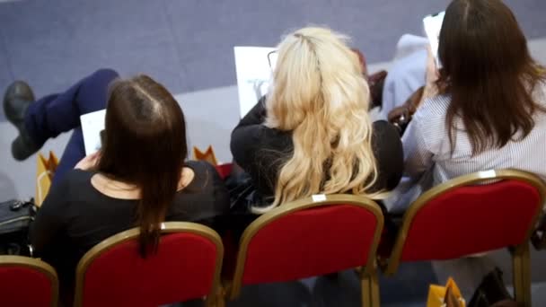 Une formation en affaires dans le hall. Trois femmes sont assises dans des fauteuils rouges et attendent que la formation commence — Video