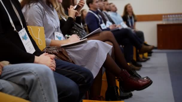 Eine Business-Konferenz in der Halle. Menschen, die im Notizbuch sitzen und Zeichen setzen — Stockvideo