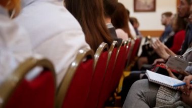 Bir iş konferansı. İnsanlar sandalyelerde oturup dersi dinliyorlar.