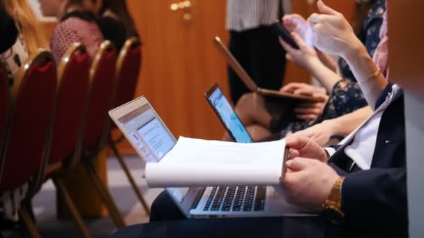 Conceito de negócio. Pessoas sentadas ao lado do laptop e fazendo anotações enquanto palestra — Vídeo de Stock