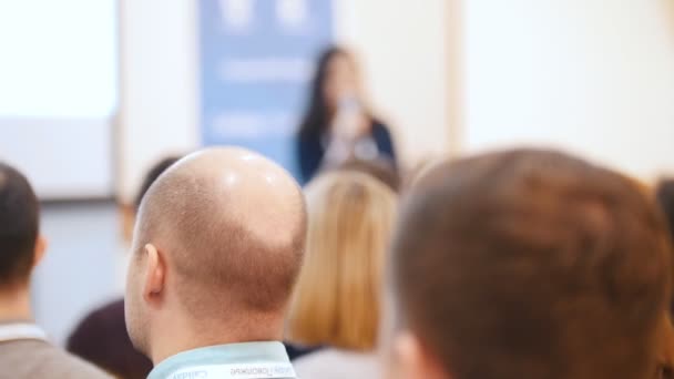 Una conferencia de negocios. Gente sentada en las sillas y escuchando la conferencia en el pasillo — Vídeo de stock