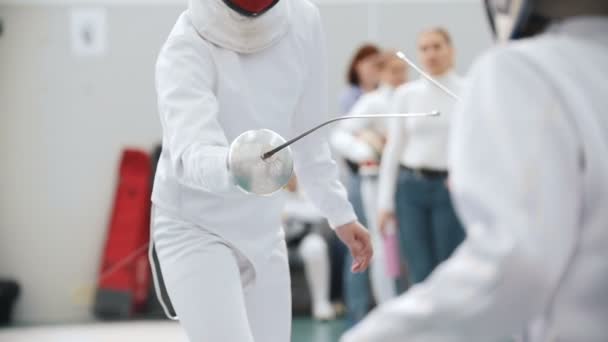 Les adolescentes debout dans le hall sur un tournoi d'escrime et se battant — Video