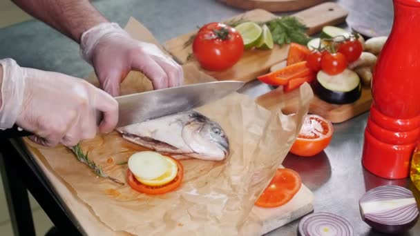 Um chef na cozinha do restaurante fazendo entalhes no peixe — Vídeo de Stock