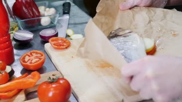 Seorang koki di dapur restoran menyiapkan ikan untuk dipanggang — Stok Video