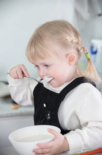 Маленькая девочка ест сметану — стоковое фото