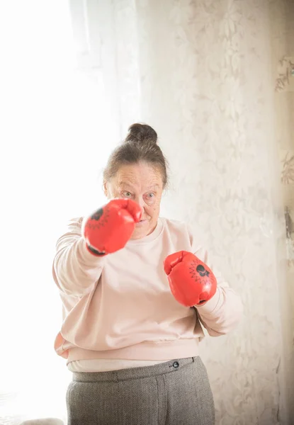 En gammal kvinna i boxningshandskar är redo att slåss — Stockfoto