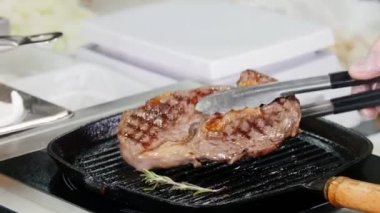 Mutfakta çalışıyorum. Şef tavadan eti çıkarıyor.